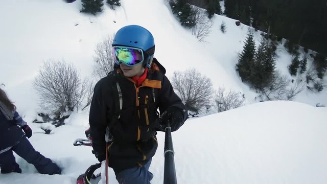 Footage of snowboarder man and woman adventure, walking to mountains