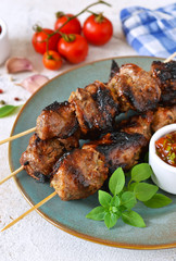 Homemade pork shish kebab with tomato sauce on a concrete background