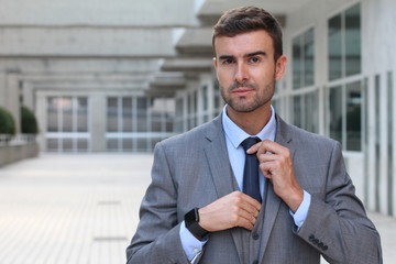 Professional man adjusting his tie 