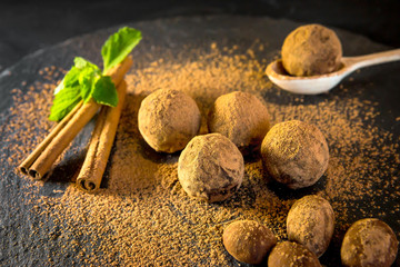 Chocolate truffle. Chocolate sweets on a table with mint and vanilla.