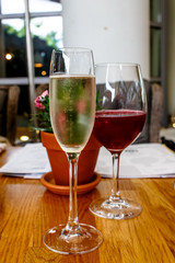 A glass of champagne and red wine are on the table.