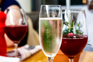 A glass of champagne and red wine are on the table.
