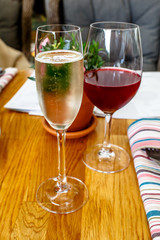 A glass of champagne and red wine are on the table.