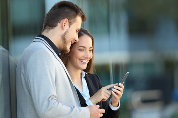 Two executives using a mobile phone on the street