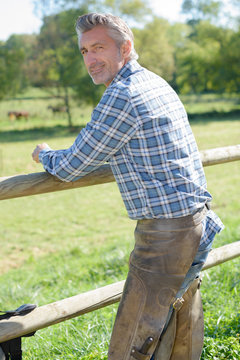farmer leaning on fence