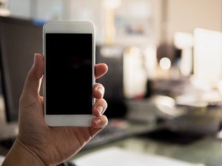 Close up man holding and using white smart phone with blank black screen,