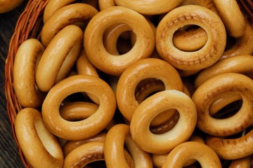 Tasty bagels in basket on wooden table 