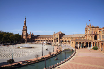 Panorama of the Spain Square (Plaza de Espana) in Seville (Sevilla), Spain with bridges over the canal, towers and main entrance to the building. Example of Moorish and Renaissance revival.