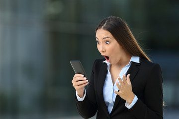 Excited executive reading amazing news on line