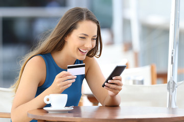 Happy woman buying on line with a smart phone