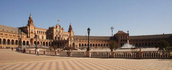 Panorama of the Spain Square (Plaza de Espana) in Seville (Sevilla), Spain with bridges over the canal, towers and main entrance to the building. Example of Moorish and Renaissance revival.