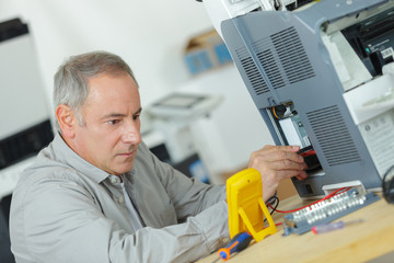 young repairer working with screwdriver in service center