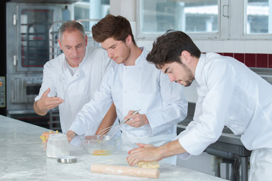 chef and trainees in restaurant kitchen