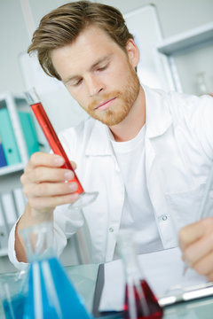 investigator checking test tubes portrait of male scientist