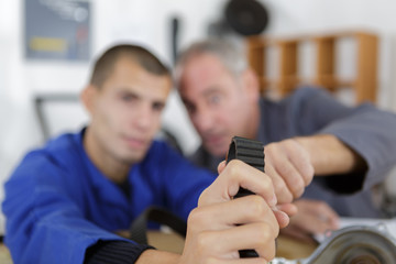 trainee and master working on industrial belt