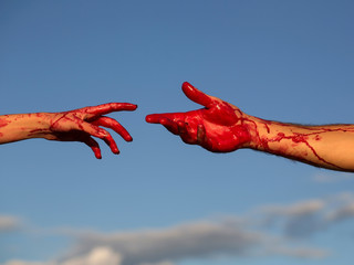 bloody zombie hands with red blood on blue sky