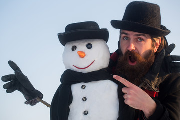 Man and snowman pointing fingers