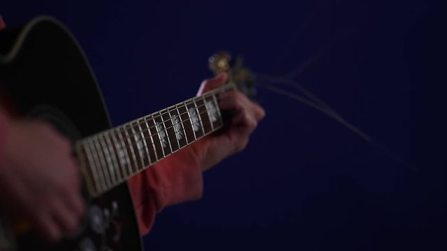 Playing acoustic guitar Side angle with focus on fretboard