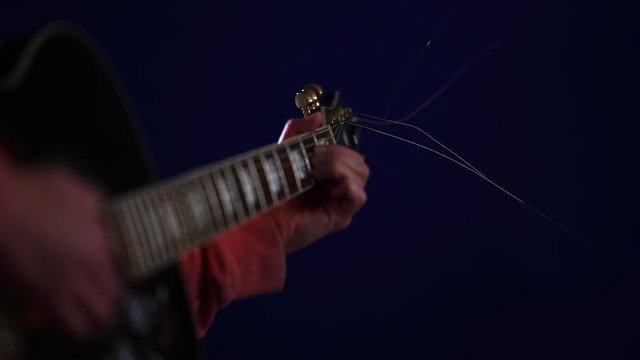 Close up Learning to play acoustic guitar on a dark background