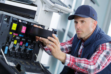 closeup shot young male technician repairing digital photocopier machine