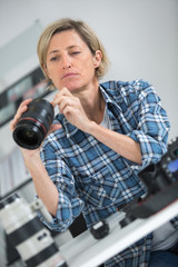 blonde woman looking at broken photographic lense