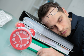 tired businessman sleeping on files