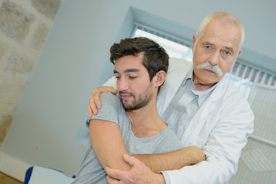 male patient seen from behind with physio therapist