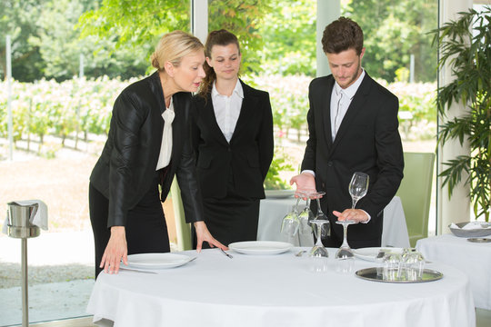 students setting up a restaurant table