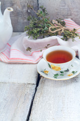 Herbal tea with thyme on rustic background