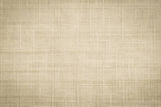Old jute hessian sackcloth canvas sack cloth woven texture pattern background in aged yellow beige cream brown color