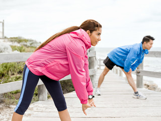 Young couple at the seaside doing exercises