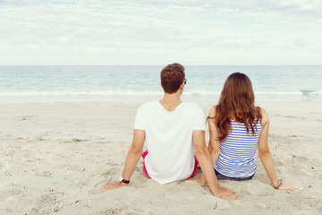 Romantic young couple sitting on the beach