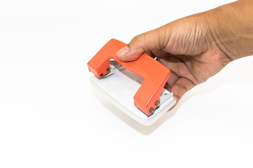 An orange paper punch on the hand of man isolated