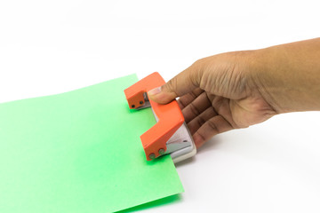 Man hand does using an orange paper punch with green paper isolated