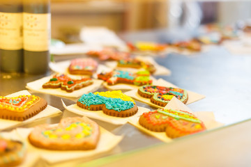 The side close-up side photo of the cookies in the form of the heart painted with the colourful creams placed on the showcase.
