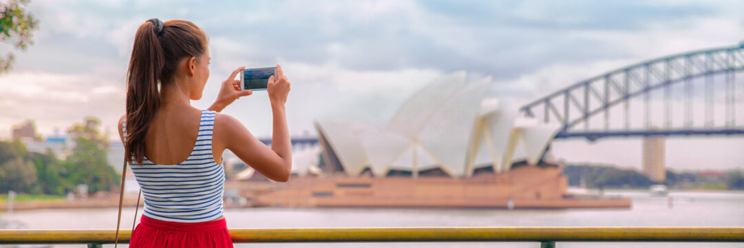 Australia Sydney travel tourist woman at Opera House panoramic banner landscape crop. Asian girl taking photos with mobile phone during summer vacation trip.