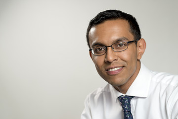 Smiling Businessman Portrait Over Gray Background with Copy Space