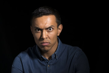 Annoyed Man in Denim Short Over a Black Background