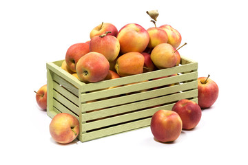 Assorted ripe apples in a wooden box on a white background