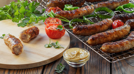 Grilled sausages and vegetables on a wooden background in rustic style. Top view