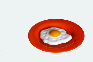 fried egg on the orange dish, isolated. A child's toy.