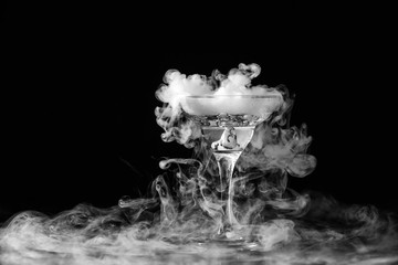 Closeup wine glass with fog at dark background. Chemical reaction of dry ice with water.