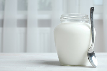 A jar of yogurt and a spoon