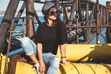 Fototapeta na wymiar Model wearing plain tshirt and sunglasses posing over street wall