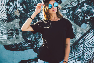 Model wearing plain tshirt and sunglasses posing over street wall - 173654886