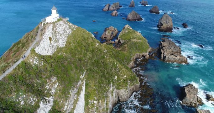 New Zealand aerial drone footage of Nugget Point Lighthouse in Otago region and peninsula on South Island of New Zealand. Beautiful tourist destination and attraction seen from above.