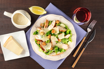 Chicken Caesar salad on rustic background with copyspace