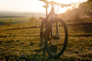 Plakat Silhouette of Mountain bike on the meadow at sunset