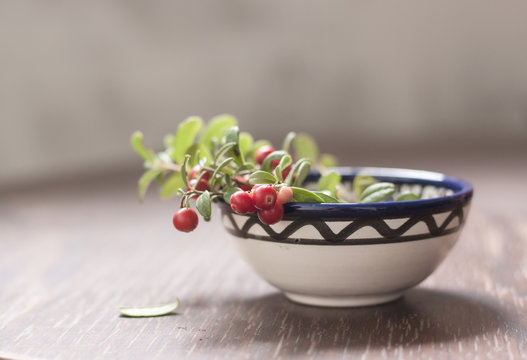 Cowberries in small ceramic dish on wood table