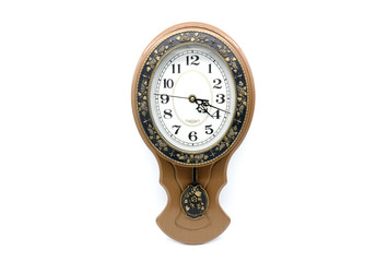 Old brown clock with pendulum and dial against white background